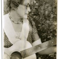 Lottie Espinosa playing the guitar, half-length portrait, photograph